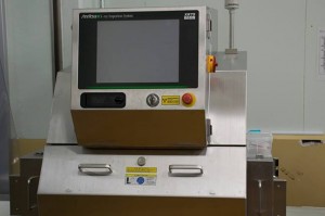 商品をビニール梱包後、再度、X線検査機を通して品質検査を行う